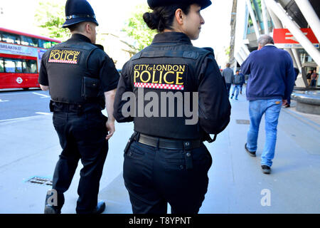 London, England, UK. Two City of London Police officers on patrol in Holborn - one male, one female Stock Photo