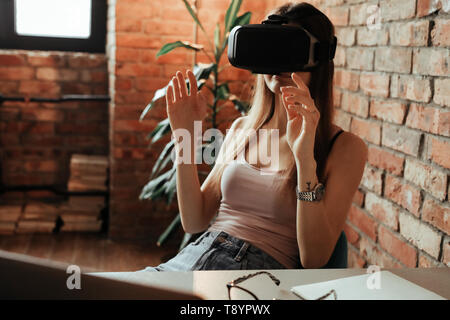 Woman wearing VR headset at home Stock Photo