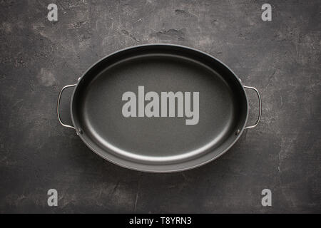 Empty Gray Nonstick Baking Dish with Handles on Dark Stone Surface. Culinary Background. Stock Photo