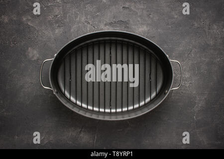 Empty Gray Nonstick Baking Dish with Handles on Dark Stone Surface. Culinary Background. Stock Photo