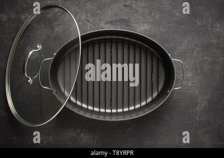 Empty Gray Nonstick Baking Dish with Handles on Dark Stone Surface. Culinary Background. Stock Photo