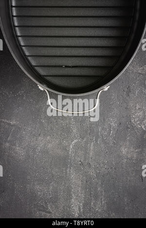Empty Gray Nonstick Baking Dish with Handles on Dark Stone Surface. Culinary Background. Stock Photo