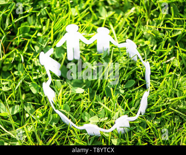 Group of paper people holding hands together. Concept of social help in group. Team concept Stock Photo