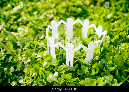 Group of paper people holding hands together. Concept of social help in group. Team concept Stock Photo