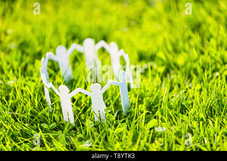 Group of paper people holding hands together. Concept of social help in group. Team concept Stock Photo