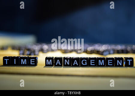 TIME MANAGEMENT concept wooden blocks on the table. With personal development and motivation concept on blurred or black background Stock Photo