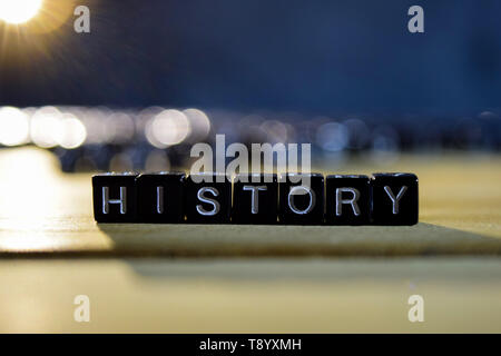 HISTORY concept wooden blocks on the table. With personal development and motivation concept on blurred or black background Stock Photo