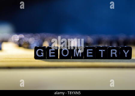 GEOMETRY concept wooden blocks on the table. With personal development and motivation concept on blurred or black background Stock Photo