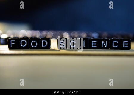 FOOD SCIENCE concept wooden blocks on the table. With personal development and motivation concept on blurred or black background Stock Photo