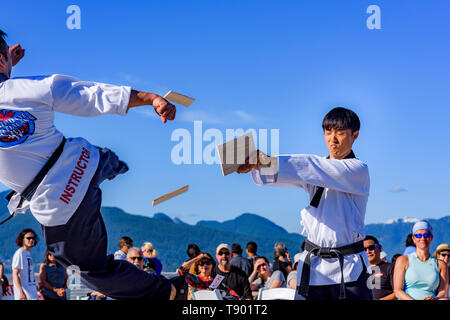 Tae Kwon Do group high kick and break wood planks at Canada 150 Multi-Cultural Day event, Canada Place, Vancouver, British Columbia, Canada. Stock Photo