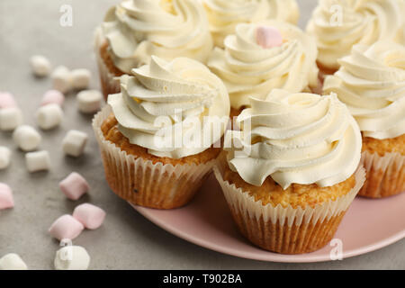 Plate with sweet cupcakes and marshmallows on grey table, closeup Stock Photo