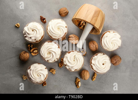 Delicious cupcakes with walnuts on grey table Stock Photo