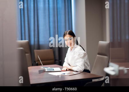 Beautiful young businesswoman using laptop in conference room Stock Photo