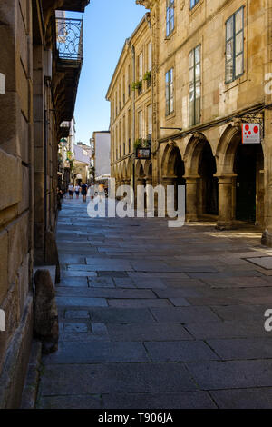Santiago de Compostela , Spain - May 12, 2019: Tourists and pilgrims roam the streets where magnificent buildings are situated in the historic Spanish Stock Photo