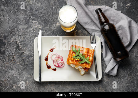 Plate with delicious waffles and glass of beer on grey table Stock Photo