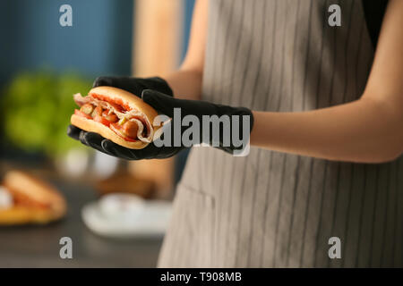 Woman holding tasty hot dog, closeup Stock Photo