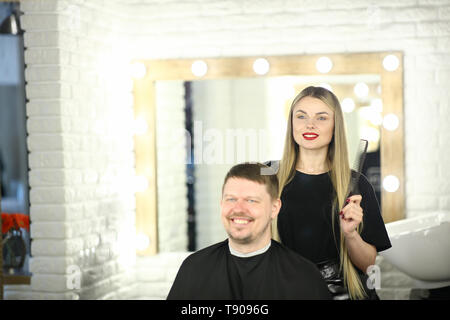 Girl Hairstylist and Man Customer in Beauty Studio Stock Photo