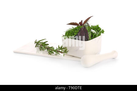 Mortar with fresh aromatic herbs and pestle on white background Stock Photo