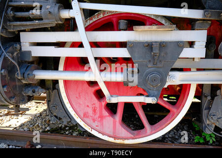 Vintage steam locomotive detail with cranks and red wheels, green bodywork, industrial heritage and transportation Stock Photo