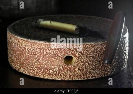 organic hay milk cheese wheel from German Allgäu region with grading iron in ripening storage Stock Photo