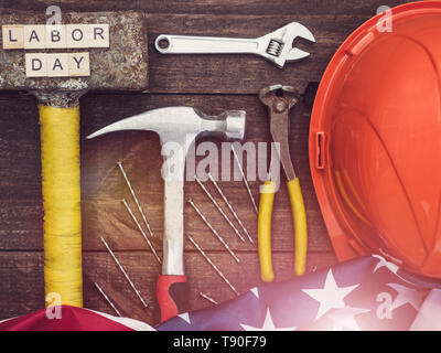 LABOR DAY. American Flag, hand tools and wooden letters of the alphabet on a wooden surface. Top view, close-up. Preparations for celebration. Congrat Stock Photo