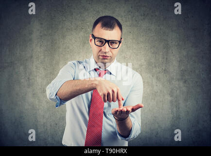 Serious business man in glasses asking for more money to pay back debt Stock Photo