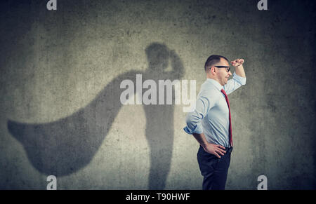 Side view of a business man imagining to be a super hero looking aspired. Stock Photo