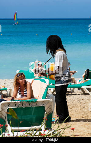 Jamaican man playing guitar on the beach for the tourist Stock Photo
