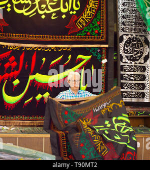 TEHRAN, IRAN - MAY 22, 2017: Seller selling carpets in local shop at Tehran Grand Bazaar. Iran Stock Photo