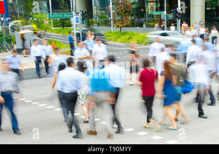 Crossing the road, business people walking at crosswalk in downtown, motion blur, Singapore Stock Photo