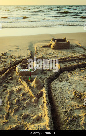 Sandcastle with moat on the Baltic beach at dusk. Summer vacation, leisure activity. Pomerania, Poland. Stock Photo