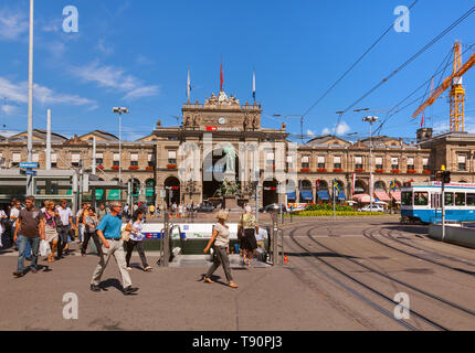 Building of the Zurich main railway station, people on Bahnhofplatz square, view from Bahnhofstrasse street Stock Photo