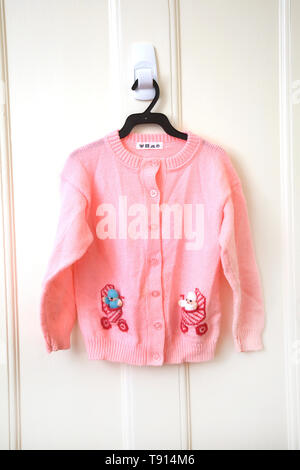 A Child's Pink Wool Cardigan with Babies in Buggys on Pockets Stock Photo