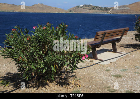 Port Korissia Kea Island Greece Bench by Bougainvillea Plant over looking the Harbour Stock Photo