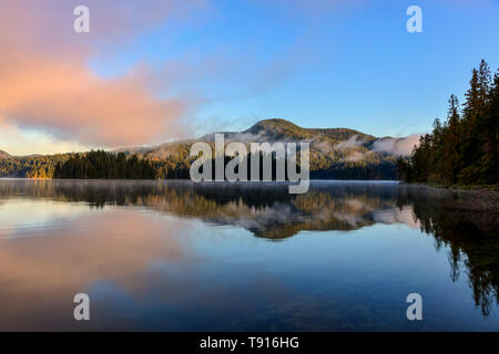 The morning sun illuminates the far shore of Main Lake, in Main Lake Provincial Park on Quadra Island, British Columbia, Canada. Stock Photo