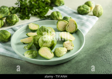Plate with fresh brussels sprouts on table