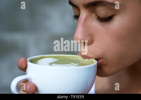 matcha latte tea ceremony of girl. Getting warm with hot tea. perfect morning with green coffee. woman drink japanese tea from cup. woman relax in Stock Photo