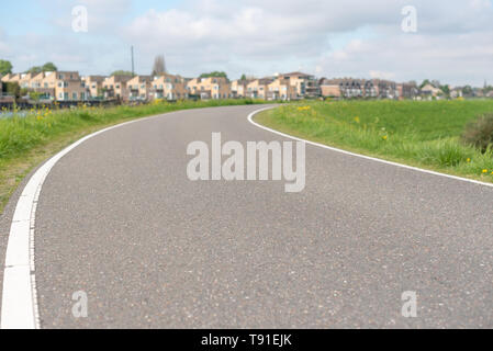 Empty curved road on a dam in the dutch countryside, Capelle Aan Den Ijssel, Netherlands Stock Photo