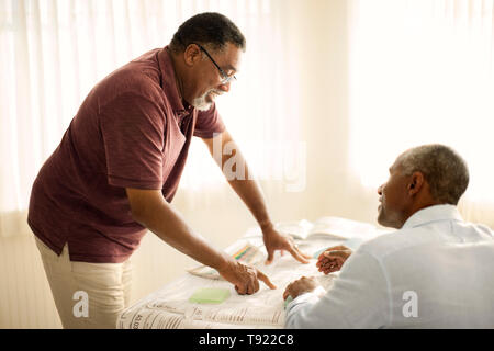 Father offering his adult son advice on home renovations. Stock Photo
