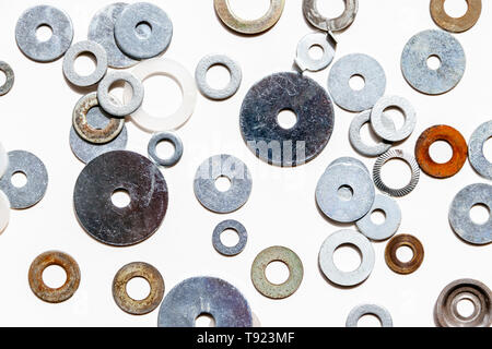 An assortment of metal washers scattered on a white background Stock Photo