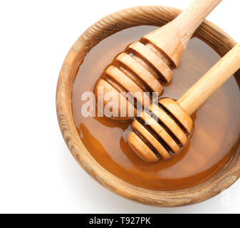 Wooden bowl with honey and dippers on white background Stock Photo