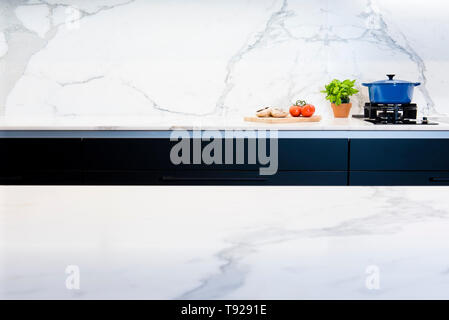 Cooking pot and ingredients on marble kitchen countertop in contemporary black and white kitchen in Australian home Stock Photo