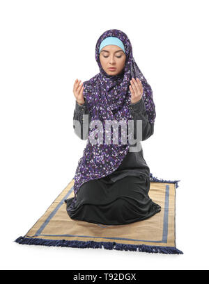 Young Muslim woman with Koran on mat, closeup. Ramadan celebration ...