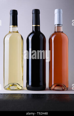 Bottles with different kinds of wine on grey background Stock Photo