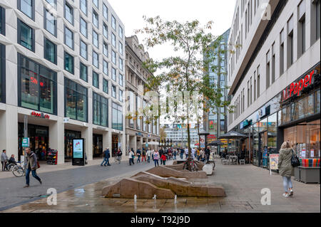 Pedestrians on street alongside with old buildings in central business district and city square near Augustusplatz in downtown Leipzig, Germany Stock Photo