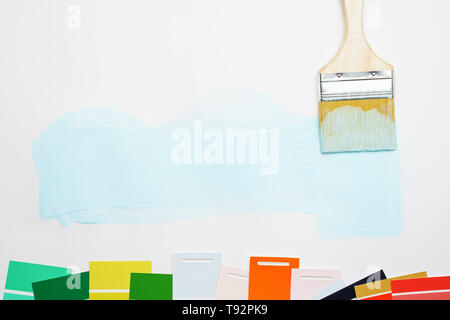 Picture of palette with blue and green, red colors, brush, on blank white background. Stock Photo