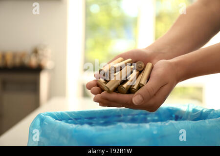 Woman throwing used batteries into recycle bin, closeup Stock Photo