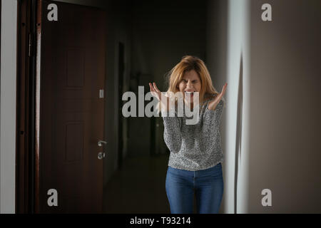 Woman having panic attack indoors Stock Photo