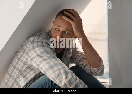 Man having panic attack indoors Stock Photo