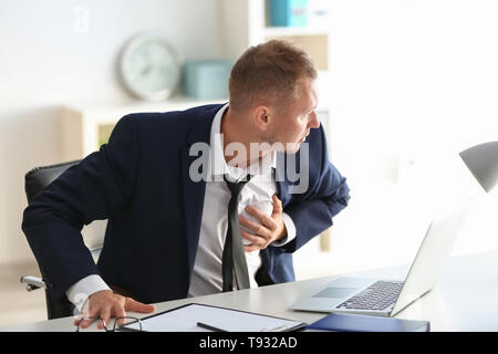 Man having panic attack at workplace in office Stock Photo
